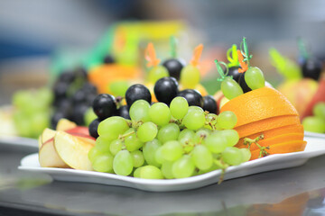 close up.plate with grapes and oranges on blurred background