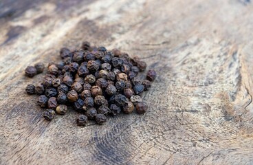 Closeup of Dry Black Pepper Isolated on Wooden Background with Copy Space