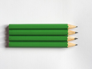 Obraz premium four green pencils on paper sheet