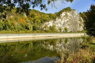 Obraz premium Les rochers majestueux entre la végétation luxuriante en automne dominant la Meuse à Anseremme au sud de Dinant 