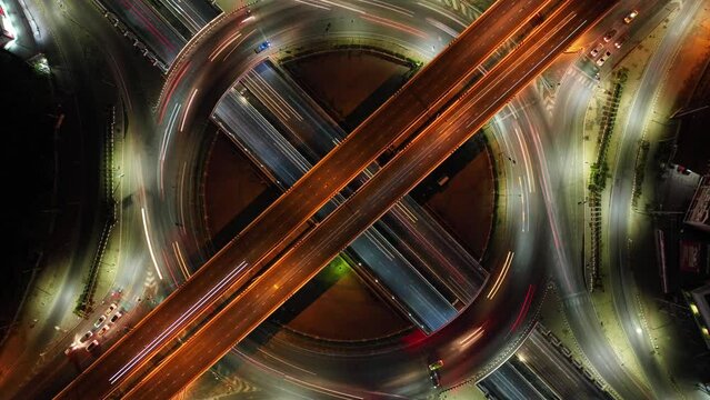Hyperlapse time-lapse of car traffic transportation above circle roundabout road in Asian city. Drone aerial view fly in circle, high angle. Public transport or commuter city life concept, expressway	
