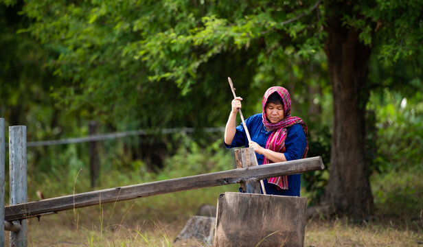 More than 70% of Thai farmers live in rural areas. Pounding rice with a wooden mortar,