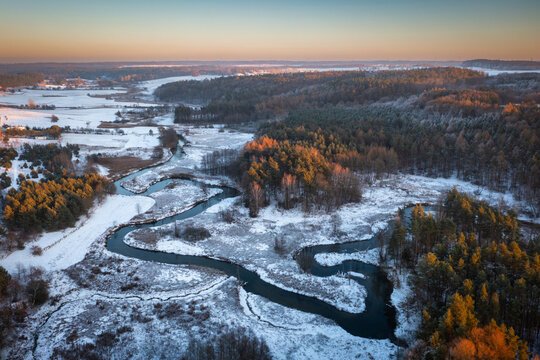 Snowy Radunia River meanders at sunset, Kashubia. Poland