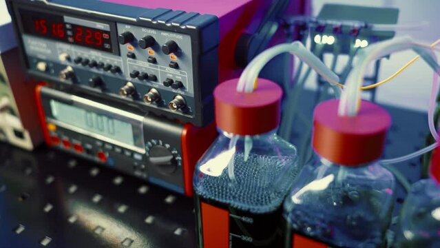 experimental bioreactors in a microbiology laboratory growing genetically modified bacteria in glass flasks control using digital measuring instruments