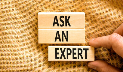 Ask an expert symbol. Concept words Ask an expert on wooden blocks on a beautiful canvas table canvas background. Businessman hand. Business and ask an expert concept. Copy space.
