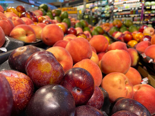 Plums and peaches piles on display