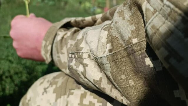 Childhood without war. Ukrainian defenders. Ukrainian defender with a child. War in Ukraine. Russian aggression against Ukraine. Peace concept. A soldier gives a flower to a child