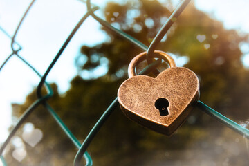 Herz - Zaun - Love - Heart - A closeup of a heart-shaped lock on a mesh fence - Valentinstag - High...