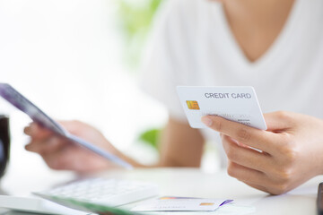 Close-up shot of young asian woman checking bills, taxes, bank balance and calculating credit card...