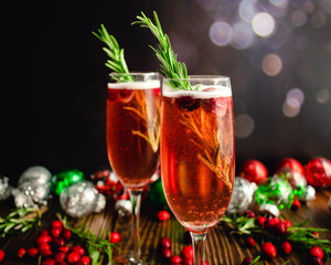 Christmas Mimosas Garnished with Sugared Cranberries and Rosemary: Champagne cocktails made with...