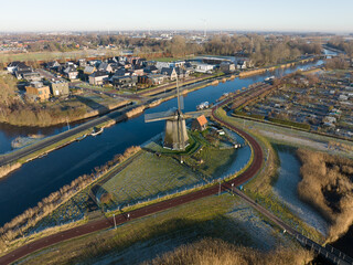 Strijkmolen E, Ouddorp, Alkmaar, North Holland,The Netherlands. Oak octagonal polder mill from 1630. Ironing mills do not drain polders, grind the water from one reservoir to the other. Winter aerial.