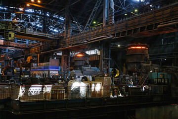 View from inside the shop of a steel mill. Ladle of hot metal at a large metallurgical plant. Melting pig iron and steel.