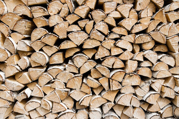 Firewood background. Dry chopped wooden logs. Natural texture.