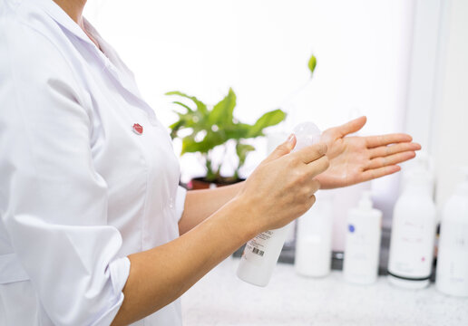 A Doctor In A White Coat Treats Hands With A Disinfectant