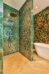a bathroom with green hexagon tiles on the walls and wood flooring around the bathtub in the shower