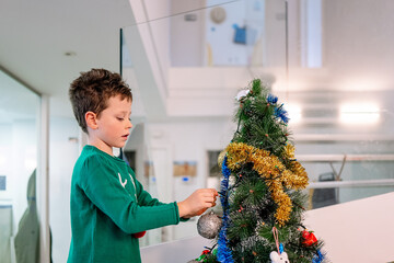Boy decorating Christmas tree at home