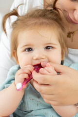 First knowledge of baby with toothbrush. Mom showing to child girl how to brush teeth. Habit of daily dental oral hygiene for children. Vertical