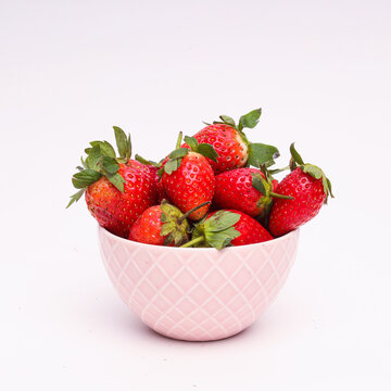Girl holding bowl full of strawberries. Strawberry fruit bowl on white background.