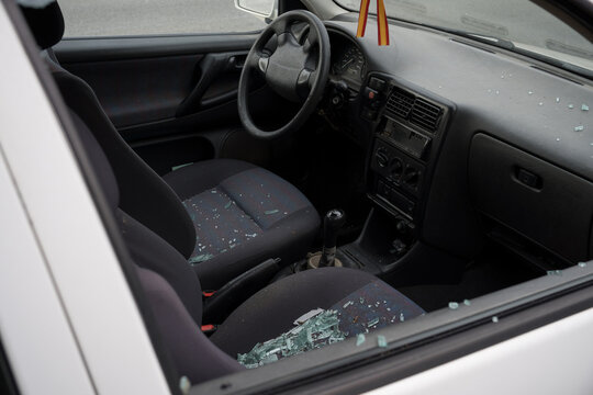 Broken window of an old car. Vandalism of a car to steal the stereo. Broken glass on the seats of a car.