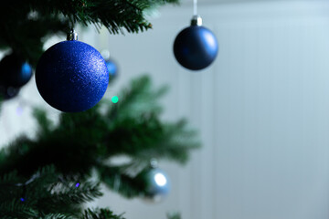 Christmas tree with blue, white balls and garland on a white background. Festive New Year's atmosphere