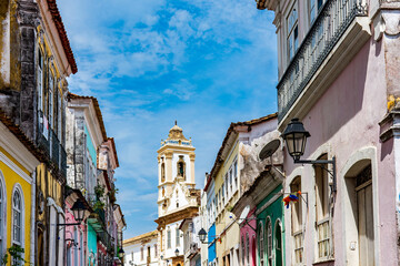 Fototapeta na wymiar Old houses with colorful facades and historic baroque church tower in Pelourinho neighborhood in Salvador Bahia