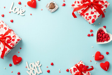 St Valentine's Day concept. Top view photo of gift boxes heart shaped candles candies inscriptions love and saucer with sprinkles on isolated pastel blue background with copyspace in the middle