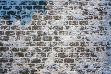 Stone urban pavement is covered with frosty snow and ice. Winter background of frozen tiled...