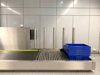 plastic containers for gadgets, hand luggage, bags rides along conveyor to be checked by airport...