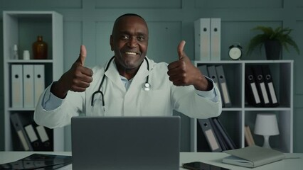 Emotional happy male doctor in white coat physician dentist general practitioner cardiologist african man recommend healthcare medicine health vaccination doing thumb up gesture approve good result