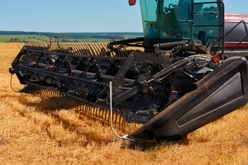 Felling on the field. A fragment of a self-propelled header with a cutting mechanism in close-up.