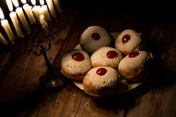 Zelfklevend Fotobehang hanukkah candle on wooden background with donuts © reznik_val