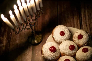 Gordijnen hanukkah candle on wooden background with donuts © reznik_val