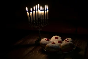 Tuinposter hanukkah candle on wooden background with donuts © reznik_val