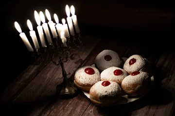 Fotobehang hanukkah candle on wooden background with donuts © reznik_val