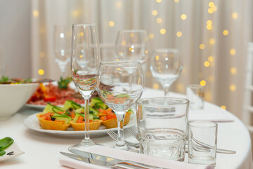 Served for holiday banquet restaurant table with dishes, snack, cutlery, wine and water glasses.