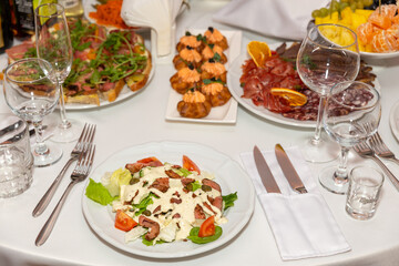 Served for holiday banquet restaurant table with dishes, snack, cutlery, wine and water glasses.