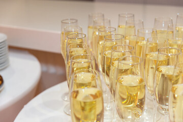 Elegant glasses with chilled champagne stand in row.