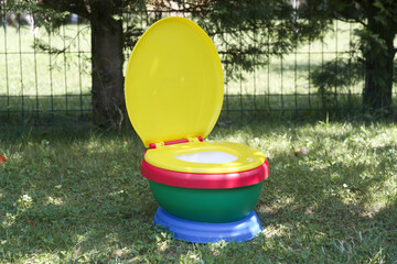 A potty standing in the shade of a tree on a green background.