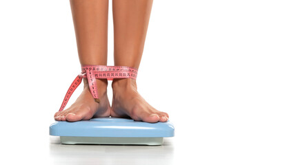 Cropped image of woman feet standing on weigh scales, on white background.