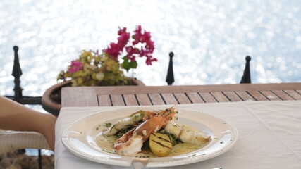 Salmon with shrimps and white wine in the restaurant with a sea view
