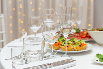 Served for holiday banquet restaurant table with dishes, snack, cutlery, wine and water glasses.