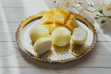 Tasty dessert Mochi with mango fruit on wooden background, close up. Traditional Japanese rice cake dessert