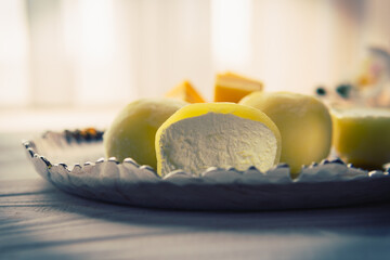 Tasty dessert Mochi with mango fruit on wooden background, close up. Traditional Japanese rice cake dessert