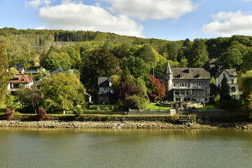 Fototapeta na wymiar Quelque villas et demeures typiques au milieu de la végétation luxuriante en automne le long de la Meuse à Lustin au sud de Namur 