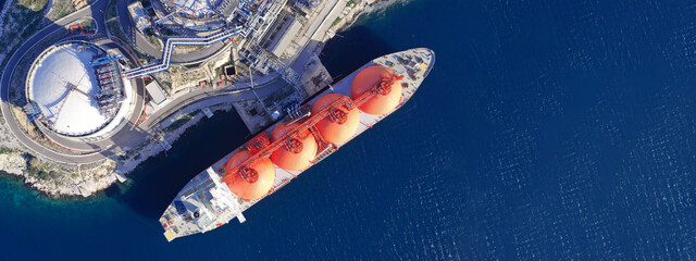 Aerial drone ultra wide photo of LNG (Liquified Natural Gas) tanker anchored in small LNG industrial islet of Revithoussa equipped with tanks for storage, Salamina, Greece - obrazy, fototapety, plakaty