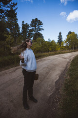 Woman walking on a dirt road holding a basket wearing a white sweater in Boulder county, Colorado - Colorado Rocky Mountain fall winter travel