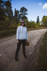 Woman walking on a dirt road holding a basket wearing a white sweater in Boulder county, Colorado - Colorado Rocky Mountain fall winter travel