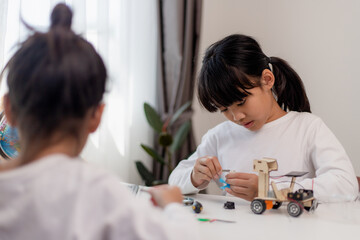 Asia students learn at home in coding robot cars and electronic board cables in STEM, STEAM, mathematics engineering science technology computer code in robotics for kids concept.