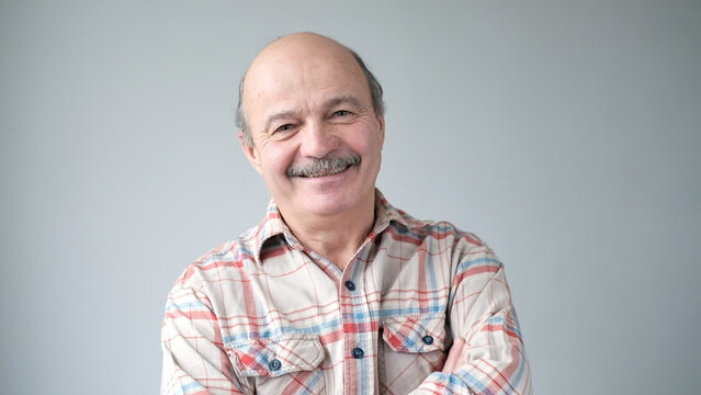 Portrait Of Smiling Mature Man Standing On White Background.