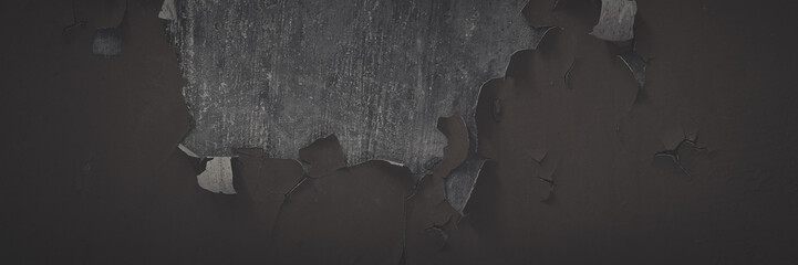 Dark wide panoramic background. Peeling paint on a concrete wall. Faded dark texture of old cracked...